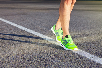 Runner man feet running on road closeup on shoe. Male fitness athlete jogger workout in wellness...