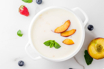 Summer healthy diet dinner, vegan food, dessert, various sweet creamy fruit & berry soups - strawberry, peach, blueberry, white marble background  copy space above close view