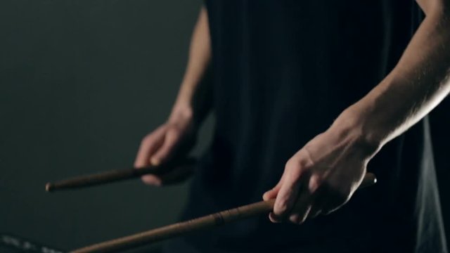 Close up shot of man's hands drum sticks on sampler and electronic pads