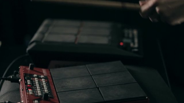 Close up shot of man's hands drum sticks on sampler and electronic pads