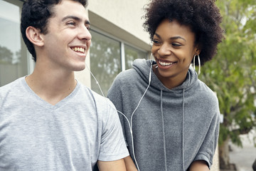 Young couple listening to music together with earphones