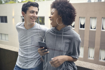 Young couple listening to music together on smart phone