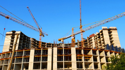 Cranes near construction building. Construction site with building and construction cranes