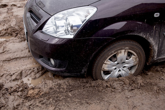 the car is stuck on a bad road in the mud