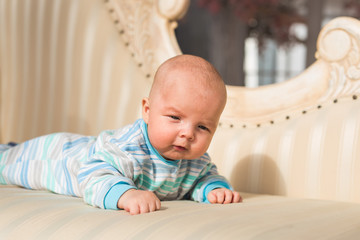 Adorable baby boy in sunny bedroom. Newborn child relaxing