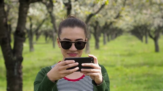 Young caucasian woman with sunglasses taking photos on her phone