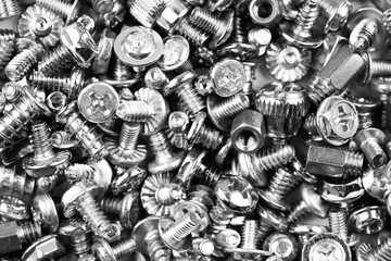 black and white background of many randomly scattered screws