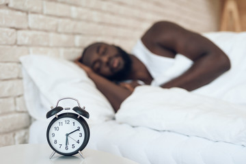 Obraz na płótnie Canvas African American man sleeps in bed