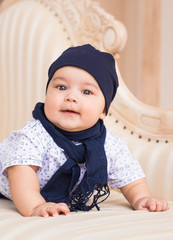 Adorable baby boy in sunny bedroom. Newborn child relaxing