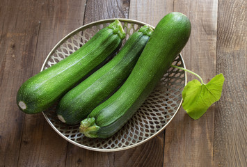three ripe gardening green oblong zucchini on the table