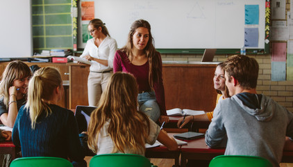 Friends study together in class room