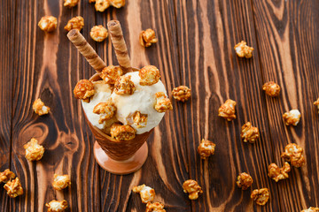 Ice cream with caramel and popcorn on a  black background. Space for text or design.