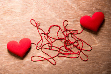 two red heart and complex red string connect together on wood background, love concept - Powered by Adobe