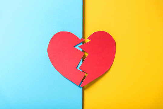 Red Paper Broken Heart On Yellow And Blue Background