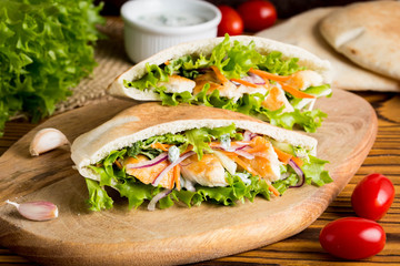 Pita with chicken, vegetables and sauce, delicious lunch, fast food, stuffed roll