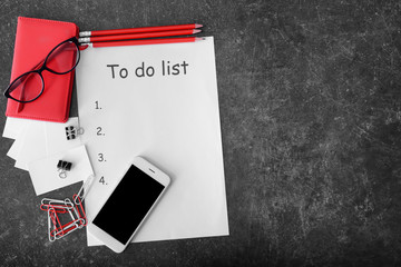 Composition with mobile phone and empty to do list on grey background