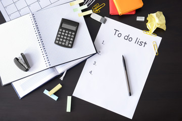 Composition with notebook, calculator and to do list on black wooden background
