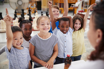 Group of kids volunteering to answer teacher's question