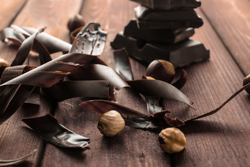 Delicious chocolate shavings and nuts on table, closeup