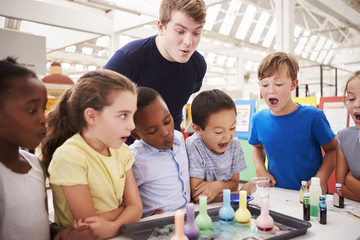 School kids and teacher watch experiment at a science centre