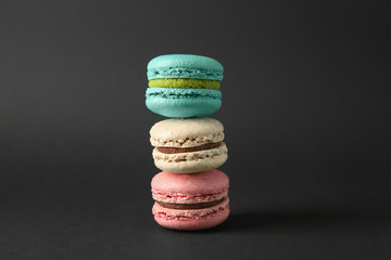 Stack of delicious macarons on dark background