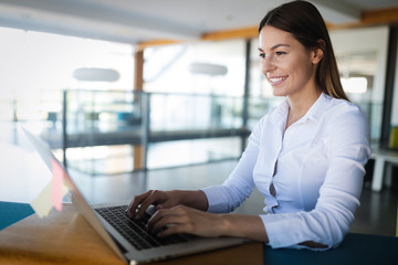 Attractive young female architect working on laptop