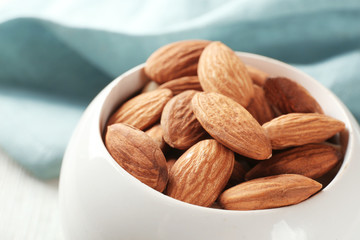 Fresh almonds in ceramic bowl, closeup