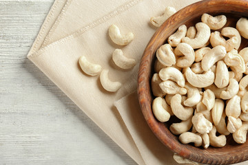 Bowl with fresh cashew nuts on table