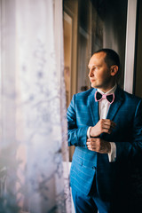 Groom morning preparation, handsome groom getting dressed and preparing for the wedding, the groom...