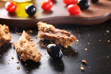 Black olive covered with oil and bread on table