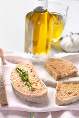 Cut bread and bottle of olive oil on table