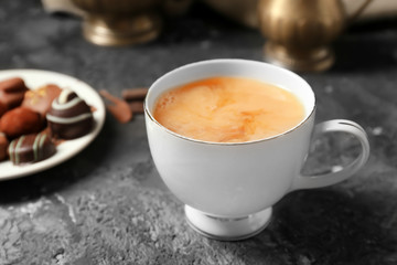 Cup of hot masala tea on grey table
