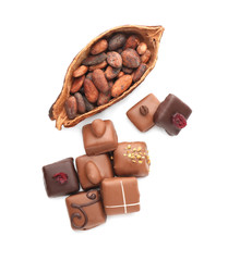 Tasty chocolate candies with cocoa pod on white background