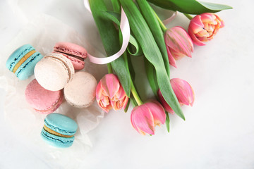 Fototapeta na wymiar Tasty macarons and tulips on light background