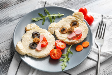 Plate with creative toasts for children on wooden table