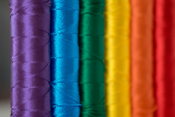 Rainbow flag. LGTB symbol made with colorful spools of thread. Selective focus.