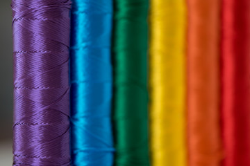 Rainbow flag. LGTB symbol made with colorful spools of thread. Selective focus.