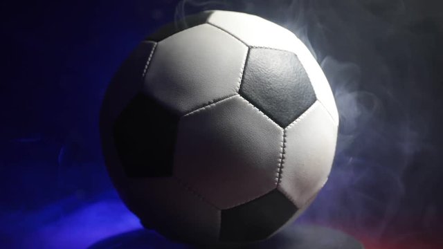 Close up view of rotating soccer ball on dark background. Football game conceptual shot.  Selective focus