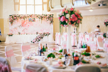 Table setting at a luxury wedding reception. Wedding decorations with flowers. Newlyweds party decor in restaurant reception.  Place for text.