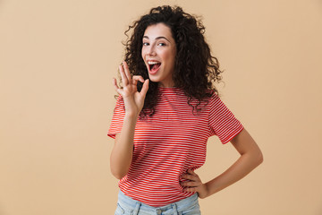 Happy emotional young woman showing okay gesture.