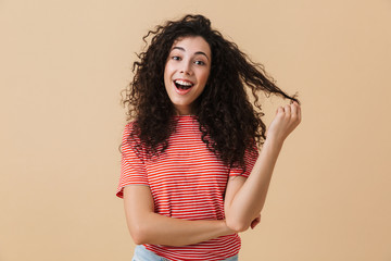 Happy young woman isolated over beige wall