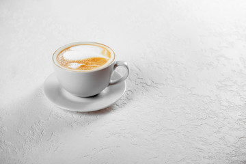 Cup of cappuccino coffee on white background