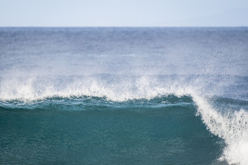 wave crash and go down in the ocean water. white sponge and blue sea perfect for nice surf activity or vacation place