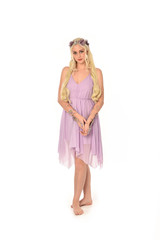 full length portrait of pretty blonde girl wearing purple fairy dress. standing pose, isolated on white studio background.