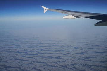 Fototapeta premium Wing of aircraft over the clouds
