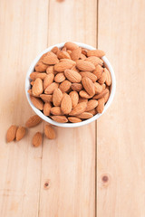 Almond nut in a ceramic bowl against wooden table