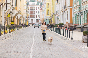 Beautiful happy woman running with husky dog at the street of old retro buildings city
