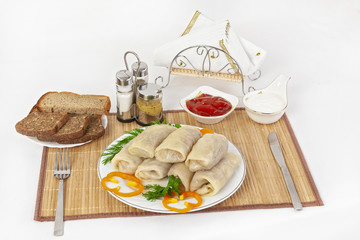 Cabbage rolls with sauce and sour cream. Usually served with black or white bread. A good seasoning for the dish is mustard.