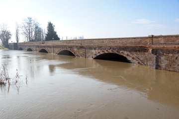 bridge with full river . River is full . Bridge to cross the river that is flooding.