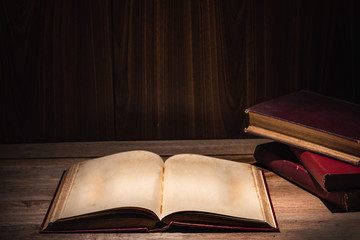 open old book neary stack of books on wooden table, vintage dark tone